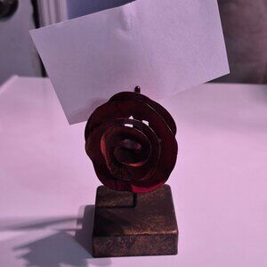 Note or picture holder. Red metal flower with a clip to hold your item.